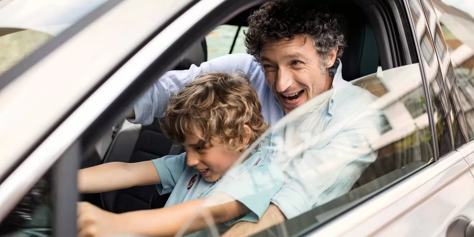 Vater und Sohn sind beim Autofahren versichert.