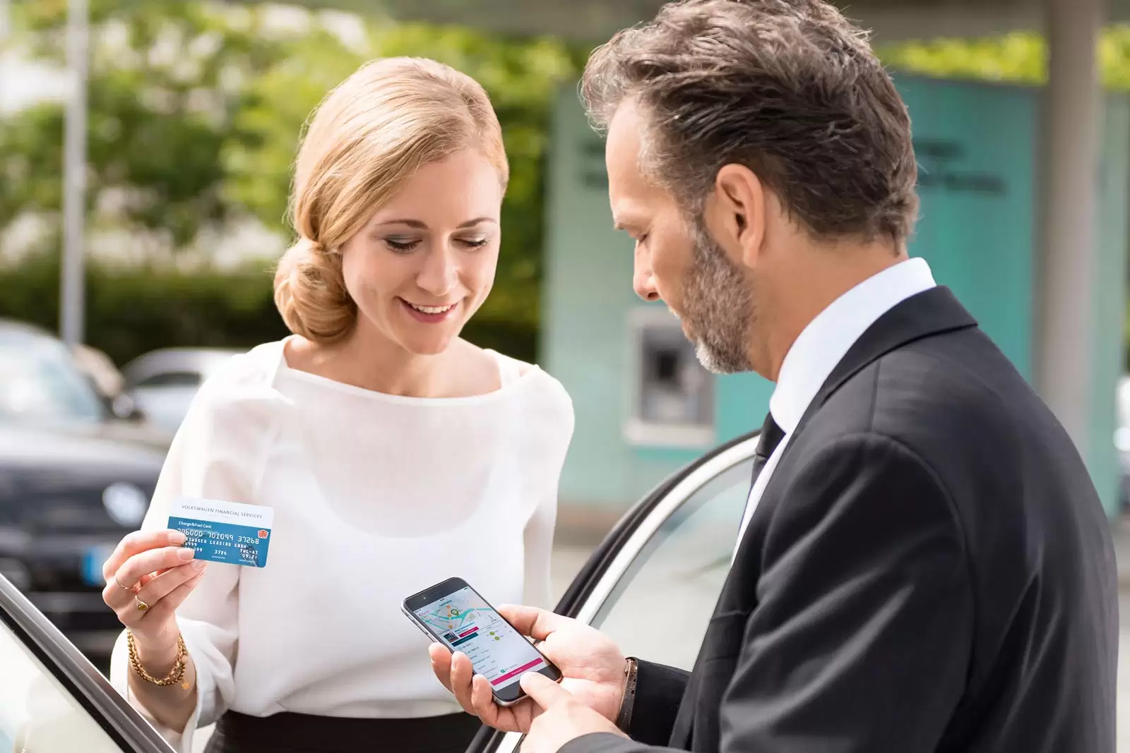 Mann zeigt seiner Frau die Charge&Fuel App auf Smartphone