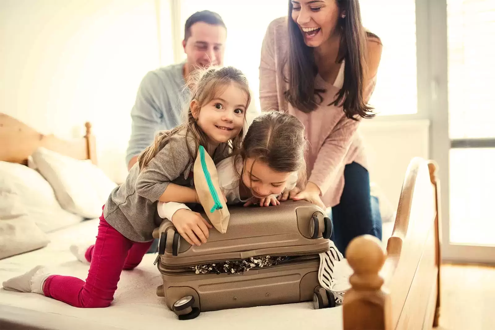 Kinder drücken mit Eltern einen Koffer zu.
